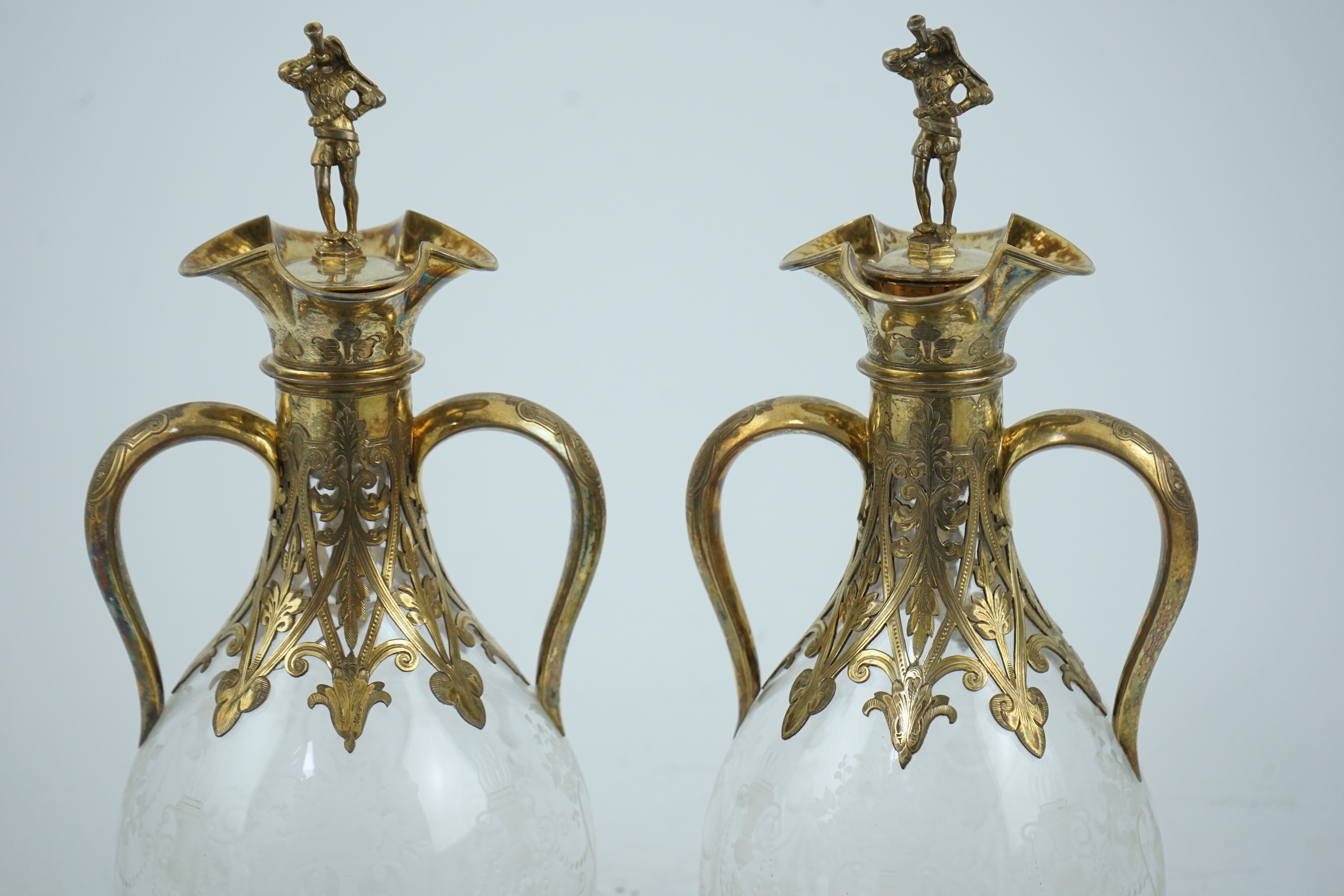 A good pair of Victorian silver gilt mounted wheel engraved glass two handled decanters and stoppers, by George Fox